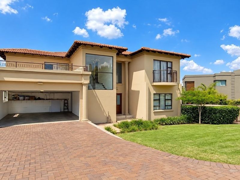 A well-maintained double-story residence featuring a paved driveway, integrated double garage, and a landscaped front garden with classic architectural detailing.