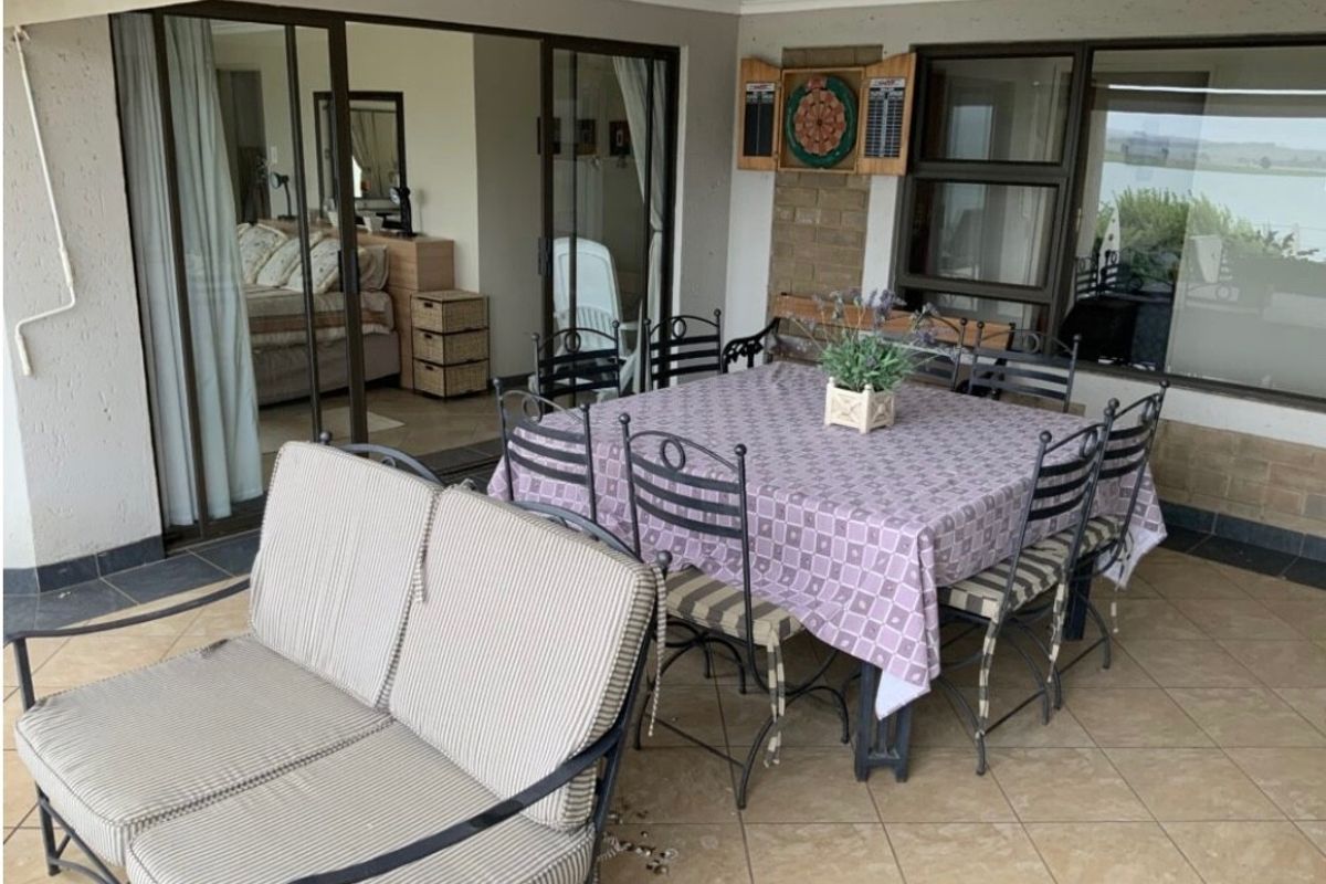 A covered patio area featuring tiled flooring, brick accents, and large sliding glass doors providing access to the interior living space.