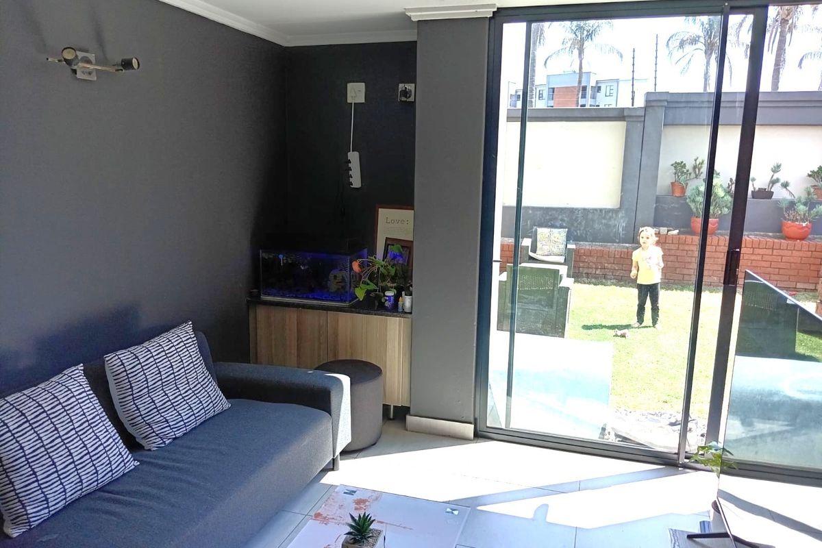 A modern living room featuring large sliding glass doors that provide direct access to a private garden area.
