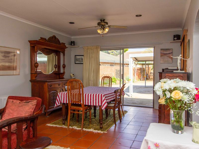 A living room featuring tiled flooring, recessed lighting, a ceiling fan, and a sliding glass door providing access to the rear patio area.