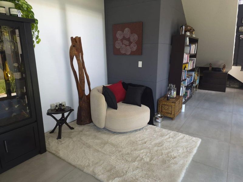 A living area featuring large format floor tiles and a dark grey feature wall, creating a modern and neutral living space.