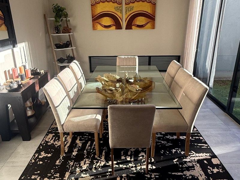 A well-lit dining room featuring large sliding glass doors that provide access to the outdoor area and modern tiled flooring.