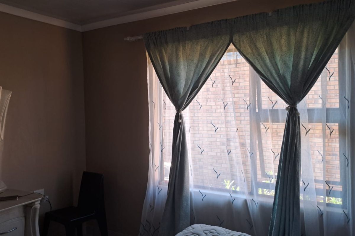 A bedroom featuring a window with natural light and standard interior finishes.