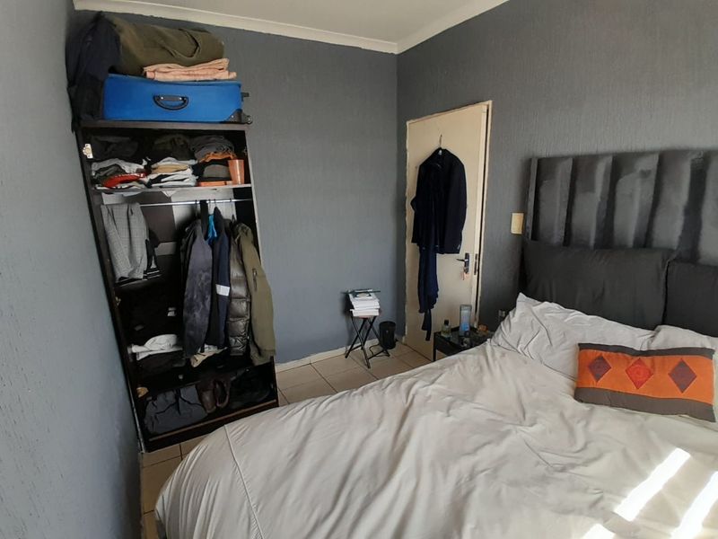 A bedroom featuring dark grey textured walls and tiled flooring, providing a neutral base for potential interior design updates.