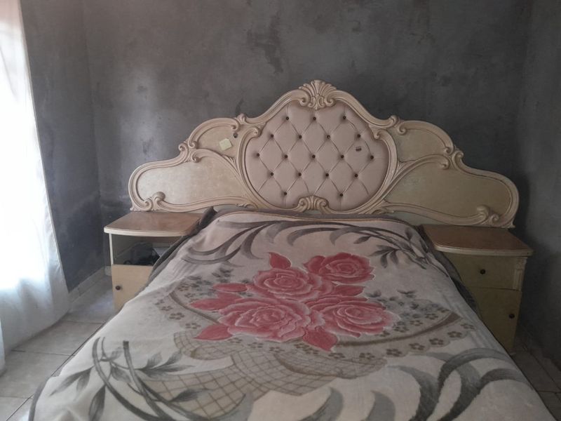 A bedroom featuring tiled flooring and unfinished, raw plaster walls, offering a blank canvas for renovation and interior design updates.