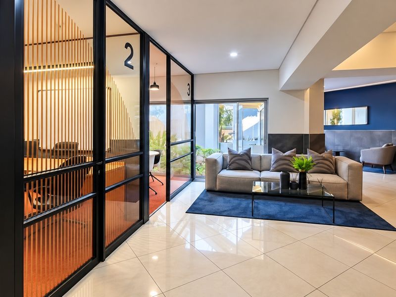 Modern office space featuring sleek glass partitions, polished tile flooring, and professional recessed lighting, creating a bright and contemporary work environment.