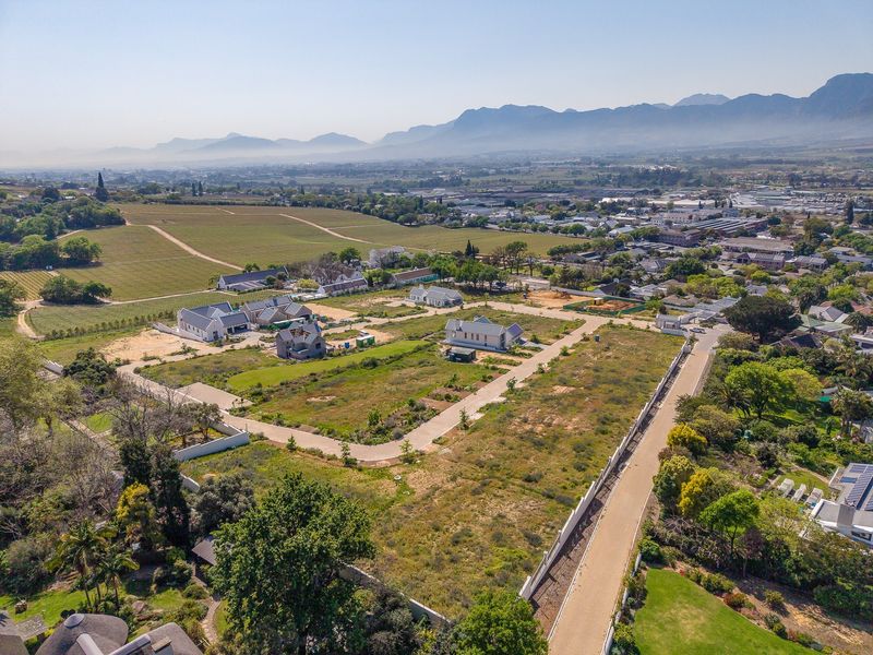 Aerial view of a residential development site featuring established internal road infrastructure and surrounding mountain landscape views.