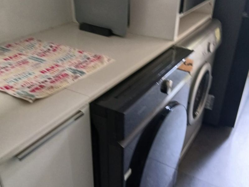 A compact laundry area featuring built-in cabinetry, a clean countertop, and an integrated washing machine.