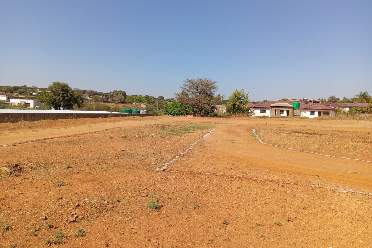 A vacant commercial land plot featuring marked boundaries and a level surface, situated in an established residential and commercial area.