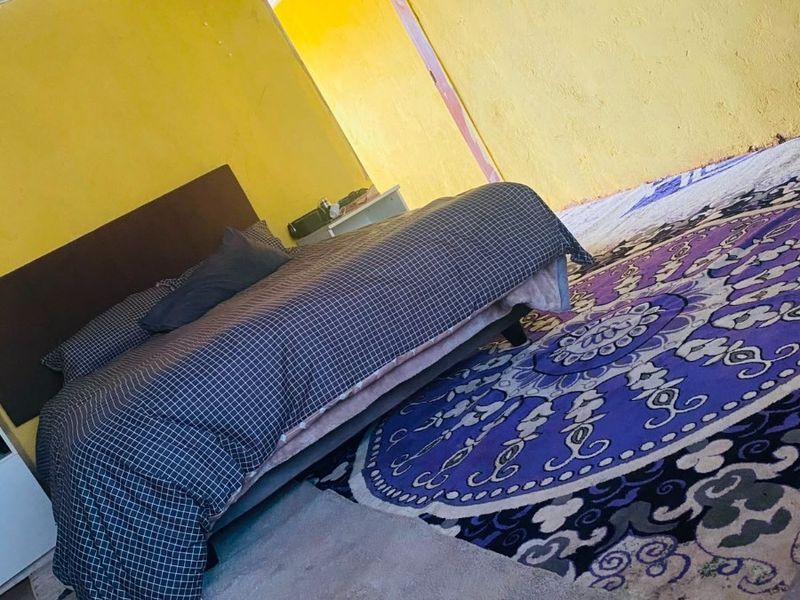 A bedroom featuring yellow walls with crown molding, requiring cosmetic updates to improve the overall finish and aesthetic appeal.