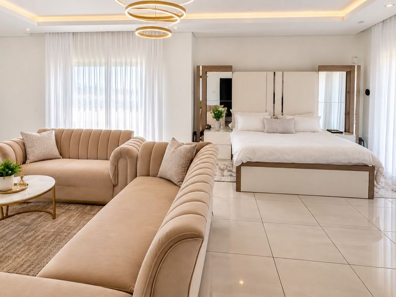 Spacious bedroom featuring modern tiled flooring, recessed ceiling lighting, and large sliding glass doors that provide ample natural light.