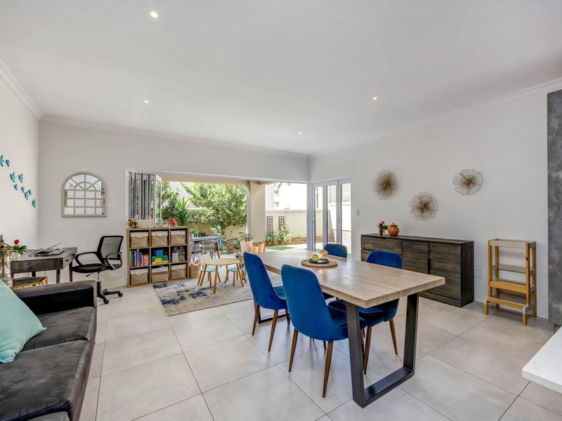Spacious open-plan living and dining area featuring large stacking doors that provide seamless access to the outdoor patio and garden.