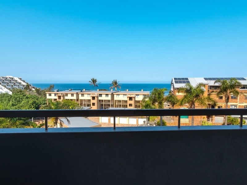 A scenic elevated view overlooking the surrounding residential complex with a clear sightline to the ocean horizon.
