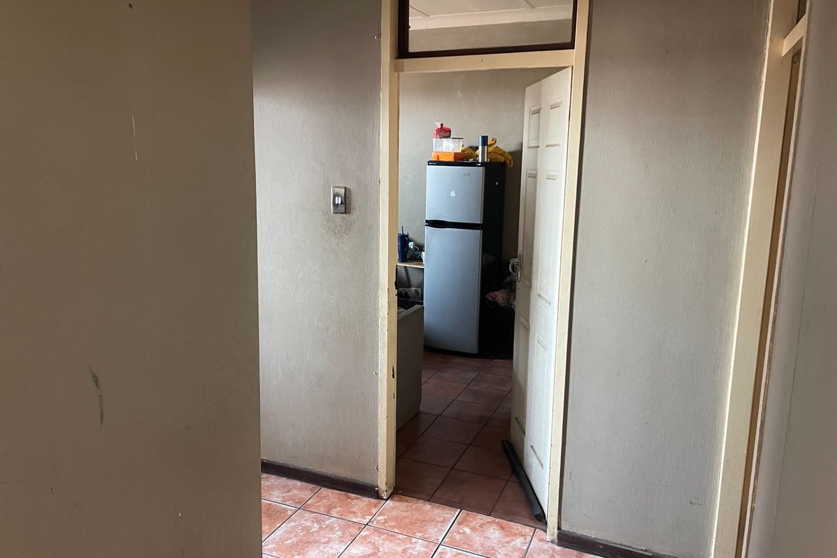 A view from a hallway looking into an adjacent room, featuring tiled flooring and neutral wall finishes.