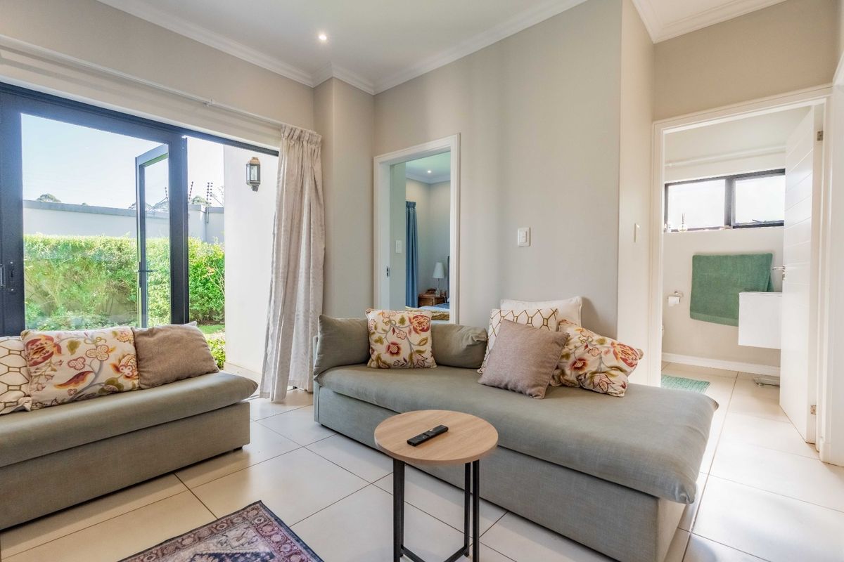 Bright living room featuring tiled floors, recessed lighting, and large aluminium sliding doors providing direct access to the outdoor area.