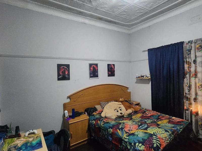 A bedroom featuring a classic pressed metal ceiling and picture rail detailing, providing a traditional architectural foundation for the space.