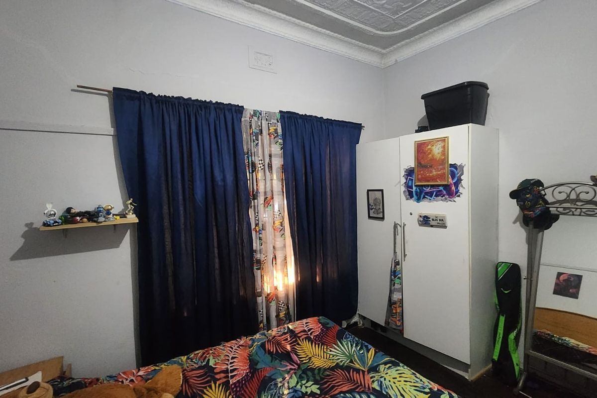 A bedroom featuring a classic pressed metal ceiling with decorative cornice and a built-in wardrobe.