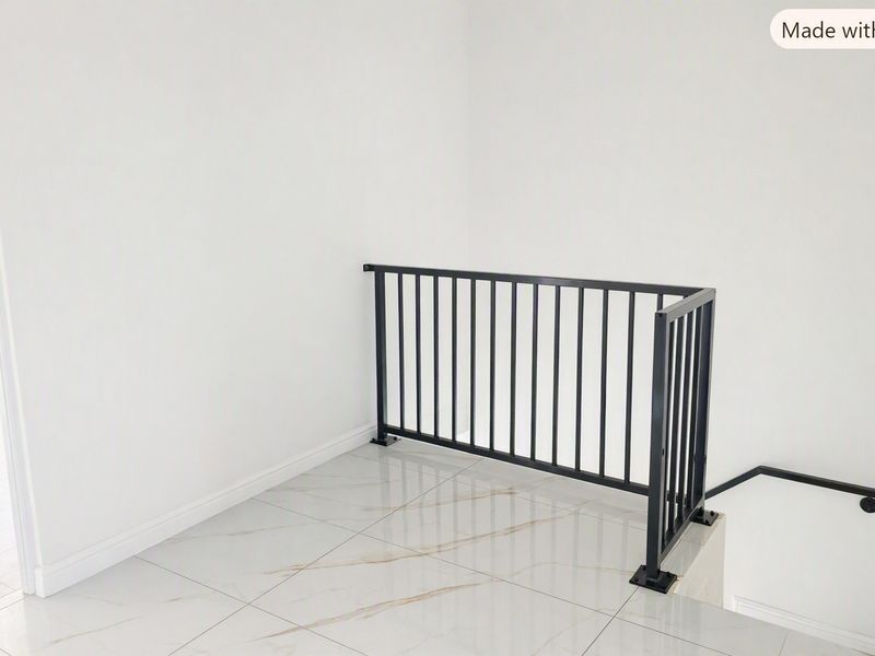 A bright, modern landing area featuring sleek marble-look floor tiles and a contemporary black metal balustrade overlooking the staircase.