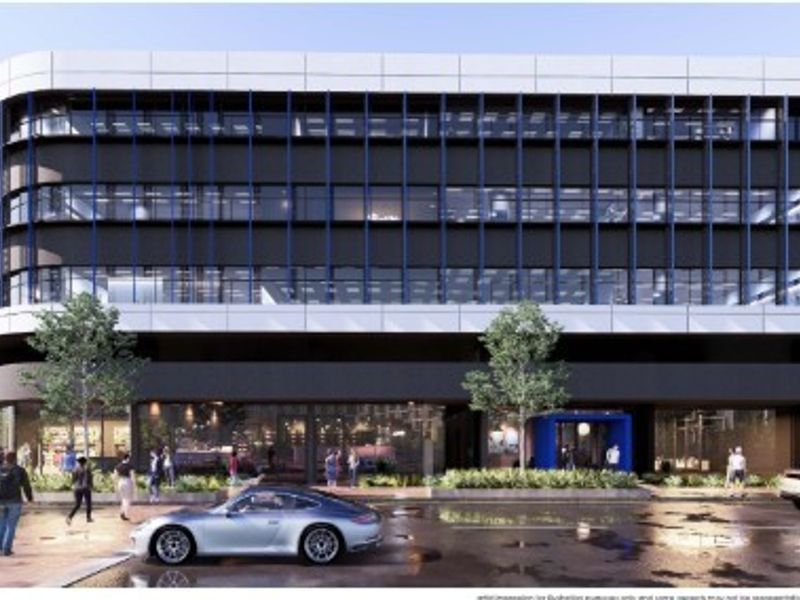 A modern multi-story office building featuring a contemporary facade with extensive glazing, architectural fins, and a prominent ground-level commercial entrance.