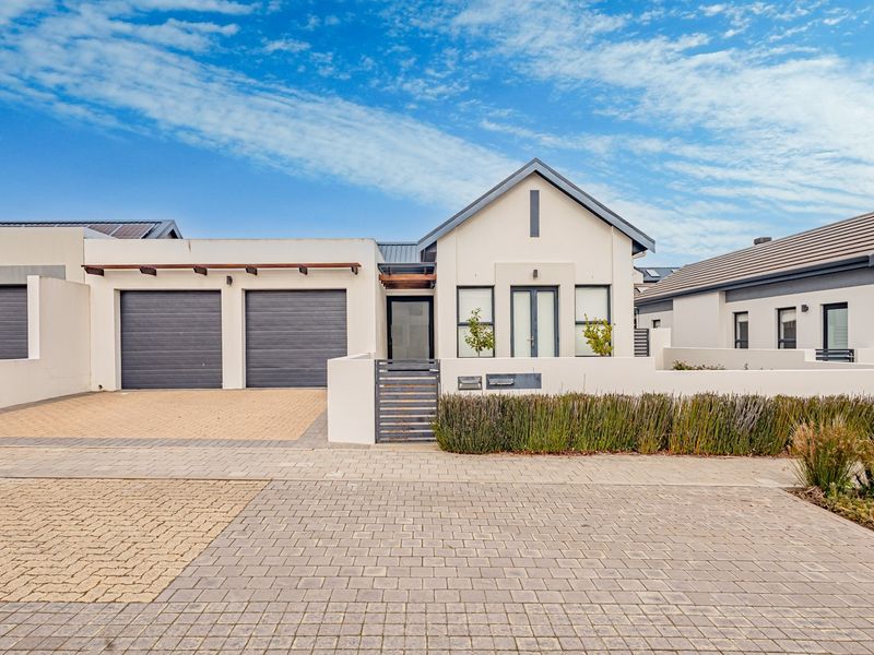 Modern single-story residential property featuring a double garage, paved driveway, and a clean, contemporary facade with a secure gated entrance.