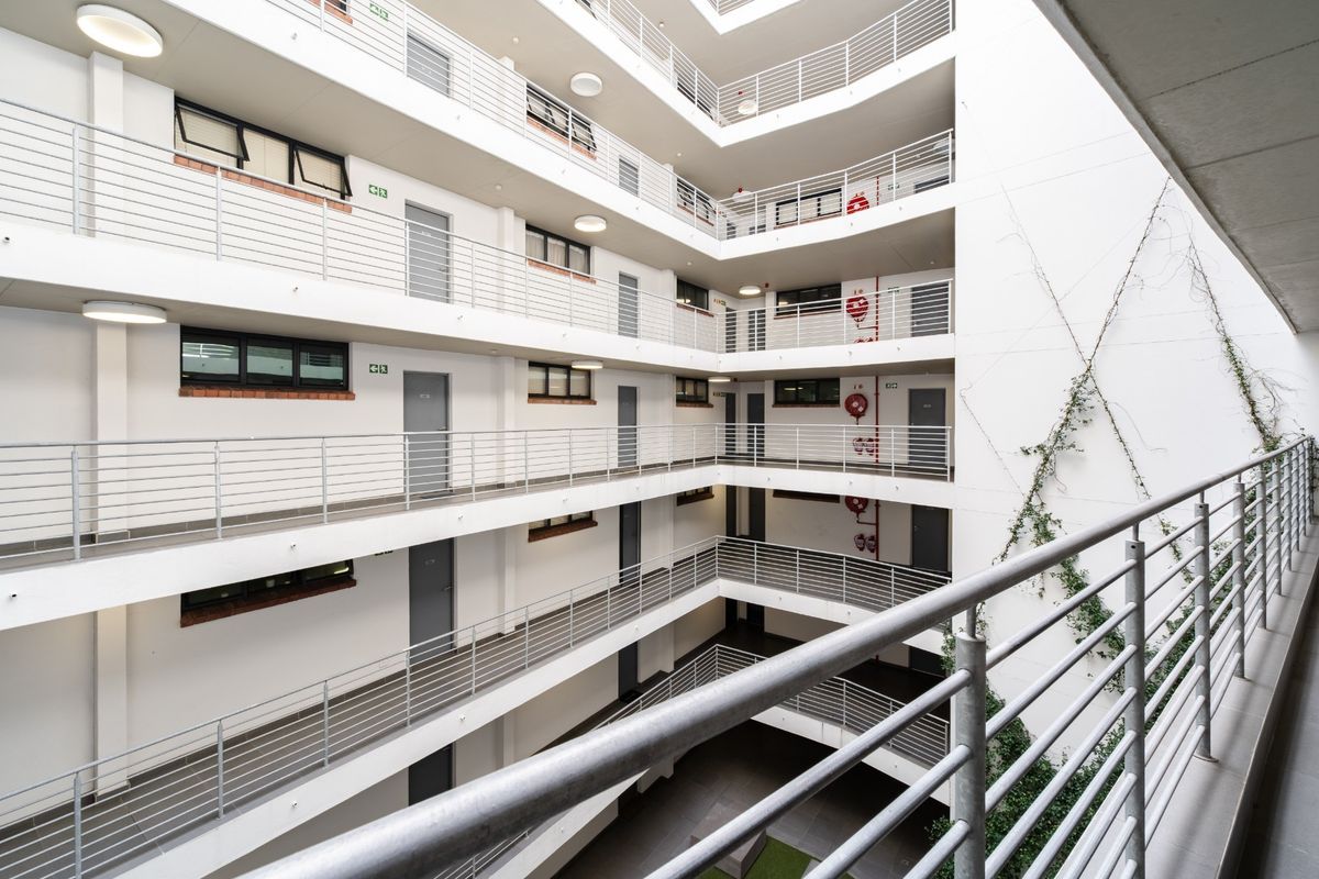 A view of the apartment complex's central atrium, featuring multi-level walkways with metal balustrades and integrated fire safety equipment.