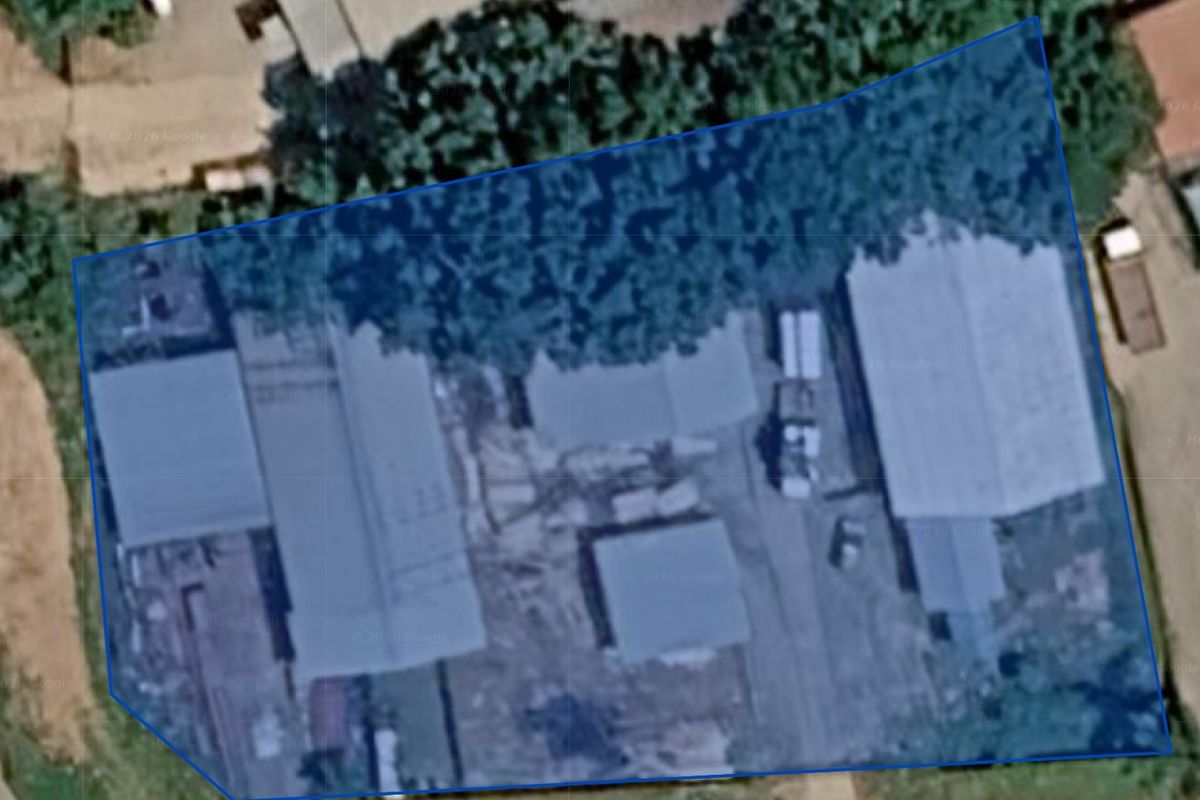 Aerial view of a commercial property site featuring multiple industrial structures and a central yard area.