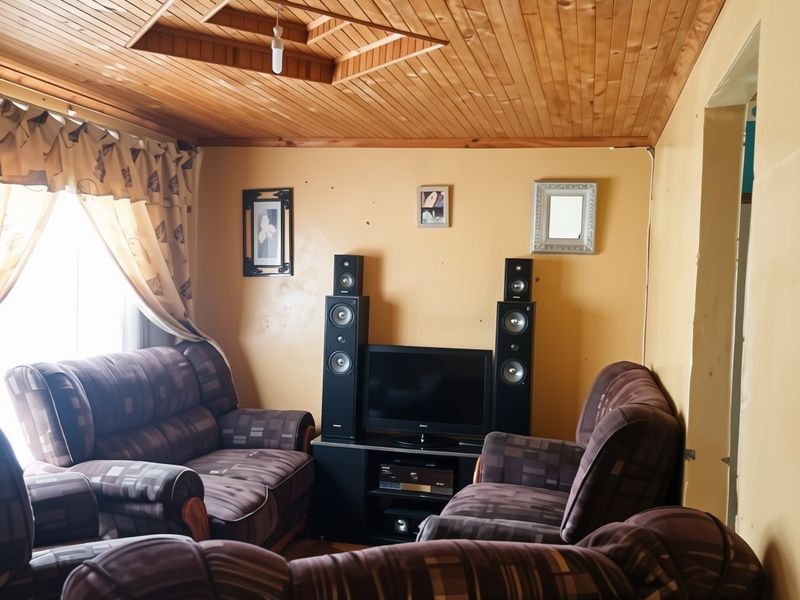A living room featuring a distinctive timber tongue and groove ceiling with a recessed architectural detail and neutral wall finishes.