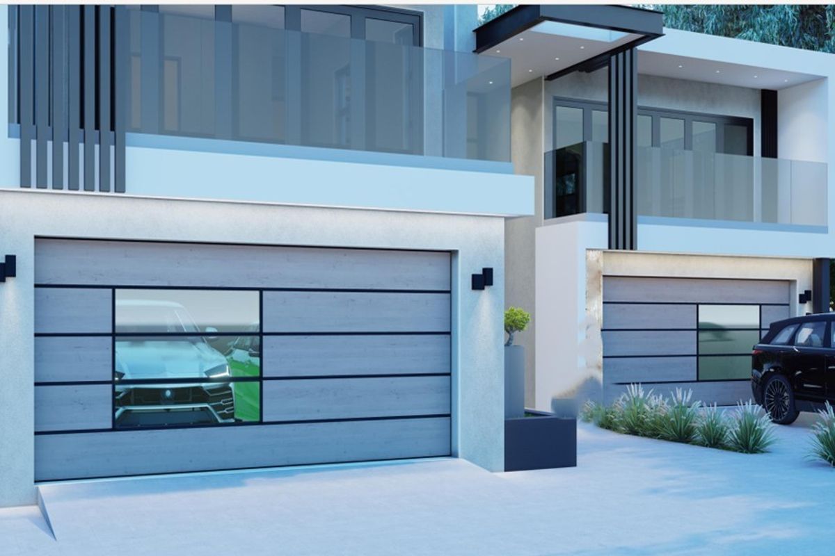 Modern double-story residential facade featuring contemporary garage doors, glass balcony railings, and clean architectural lines.