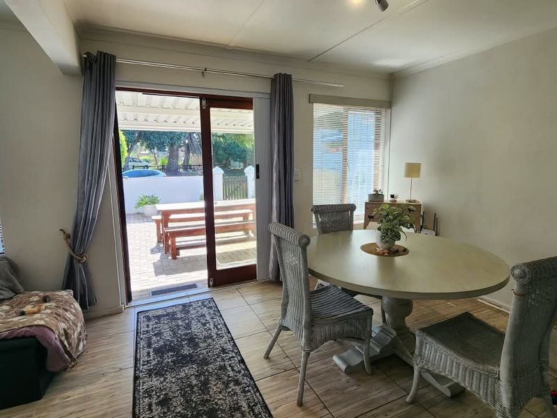Open plan living and dining area featuring tiled flooring, a staircase, and sliding glass doors providing direct access to the outdoor patio.