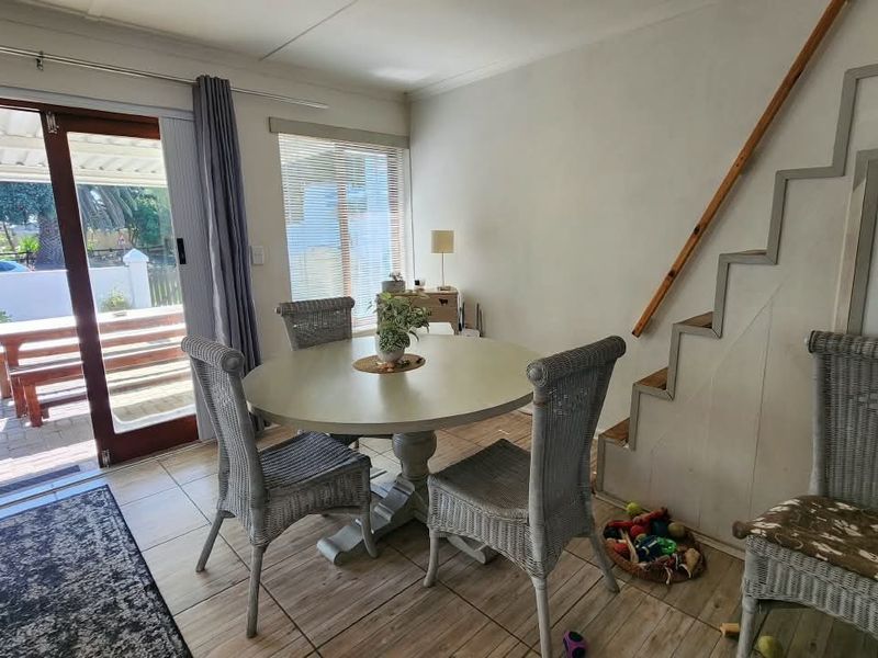 Dining area featuring tiled flooring, a staircase, and a sliding glass door providing direct access to the outdoor patio.
