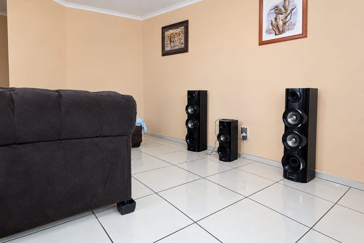 A living room featuring light-colored tiled flooring and neutral wall finishes, providing a clean and functional space.