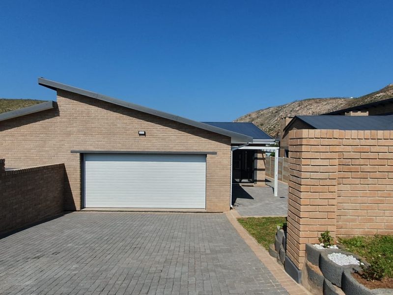 Front view of a modern duet property featuring a brick facade, single garage, and paved driveway with a clean, well-maintained exterior.