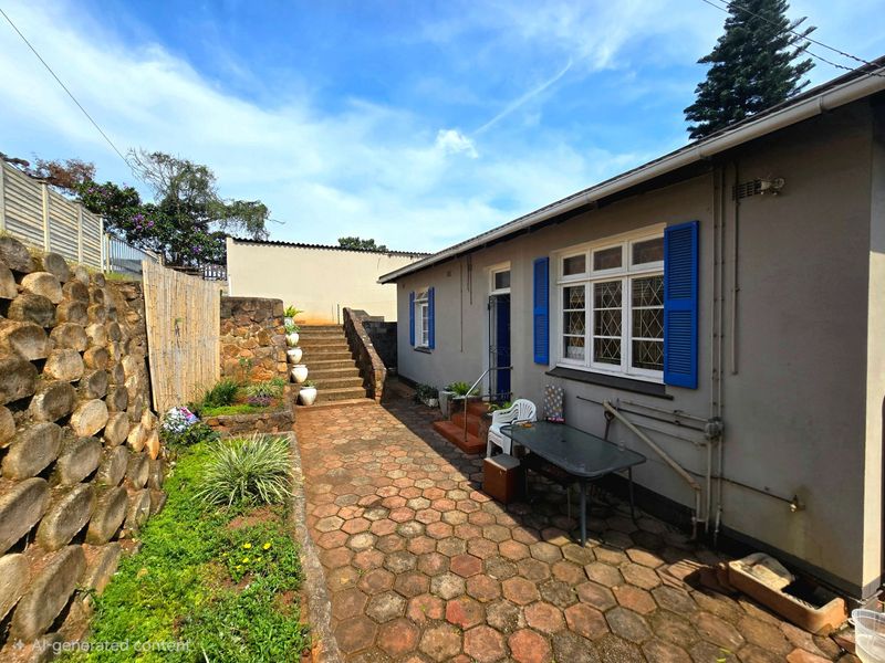 Rear exterior view featuring a paved walkway, stone retaining wall, concrete stairs, and a house facade with blue shutters and casement windows.