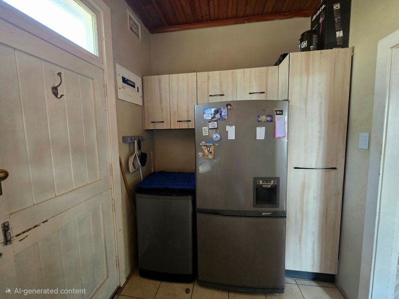 A functional laundry area featuring built-in cabinetry, tiled flooring, and a timber ceiling, providing practical storage and utility space.