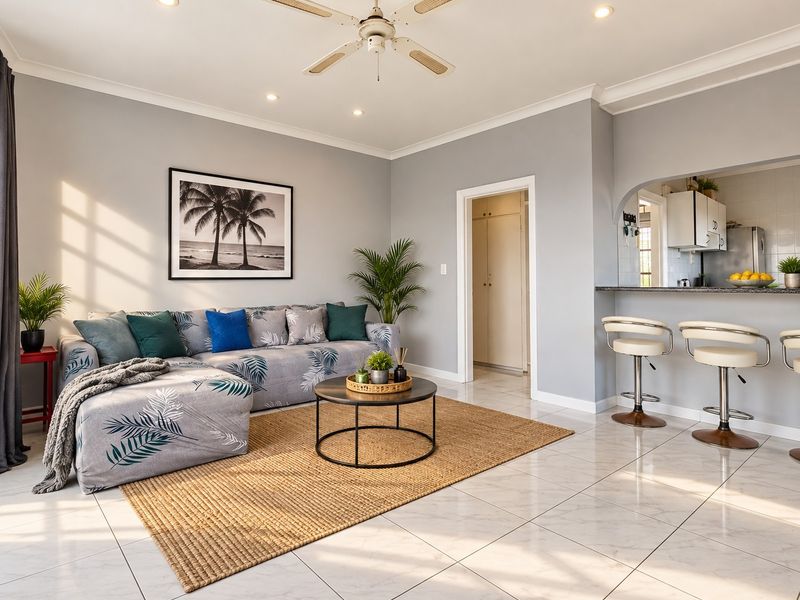 Bright open-plan living area featuring marble-look tiled flooring, recessed lighting, a ceiling fan, and a breakfast bar connecting to the kitchen.