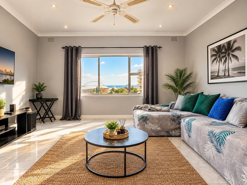 A bright and well-maintained living room featuring tiled flooring, a ceiling fan, recessed lighting, and a large window with scenic views.