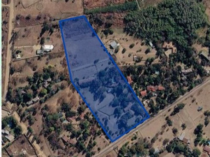 An aerial view of a vacant residential land parcel, highlighting the property boundaries and surrounding natural vegetation.