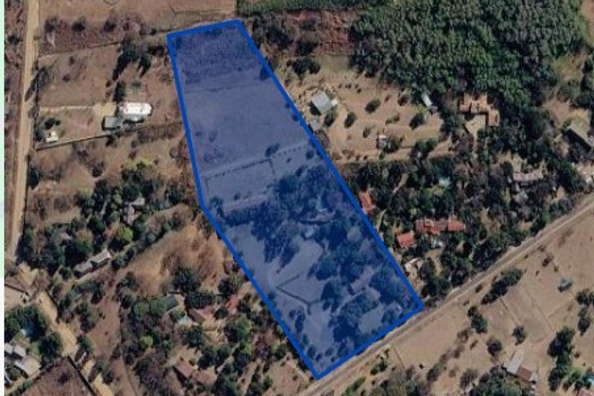 An aerial view of a vacant residential land parcel, highlighting the property boundaries and surrounding natural vegetation.