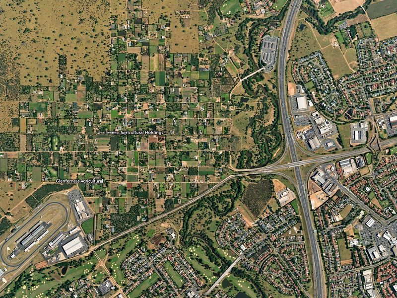 An aerial view of the Glenferness Agricultural Holdings area, showcasing the surrounding landscape, road infrastructure, and nearby residential developments.
