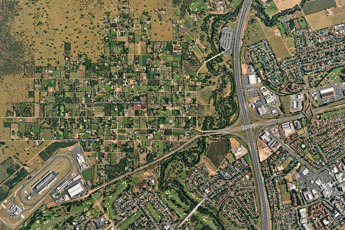 An aerial view of the Glenferness Agricultural Holdings area, showcasing the surrounding landscape, road infrastructure, and nearby residential developments.