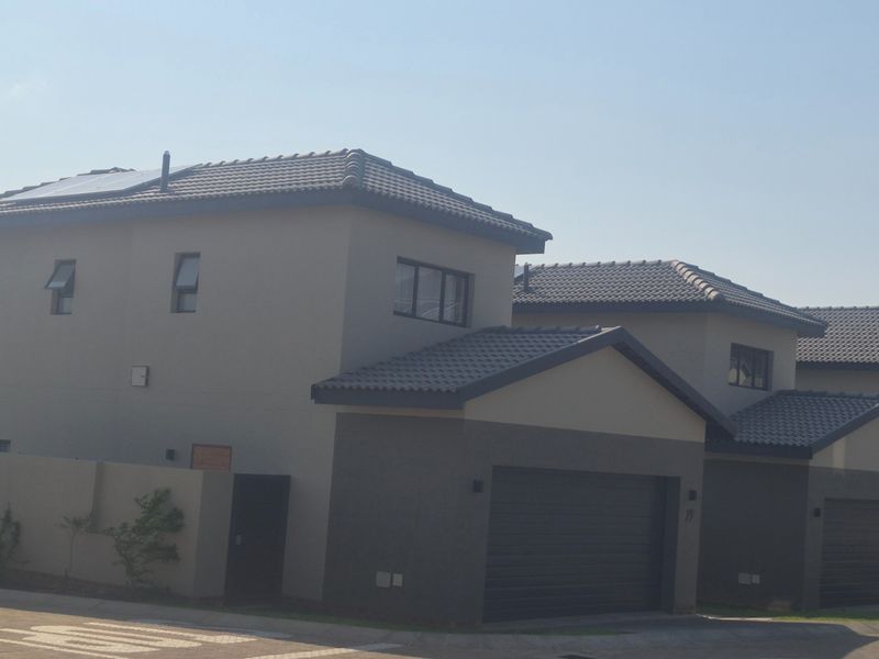 Front elevation of a modern double-story residential property featuring a tiled roof, solar panels, and an integrated garage.