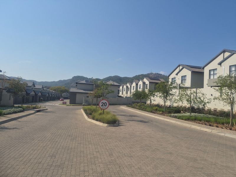 A view of the paved internal street and residential housing units within a well-maintained estate complex.