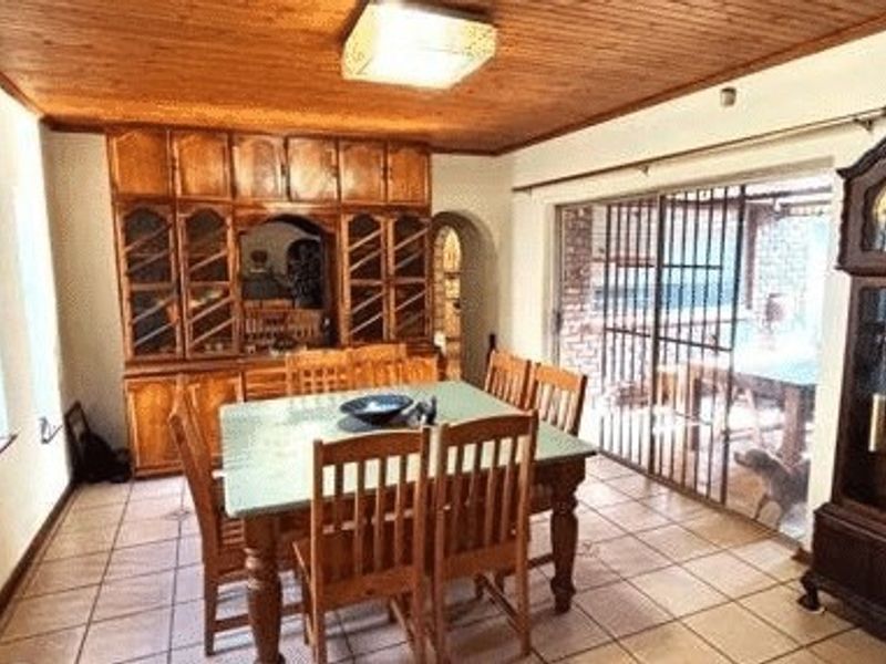 Dining room featuring tiled flooring, a timber ceiling, and extensive built-in cabinetry, with direct access to an outdoor patio area through sliding glass doors.