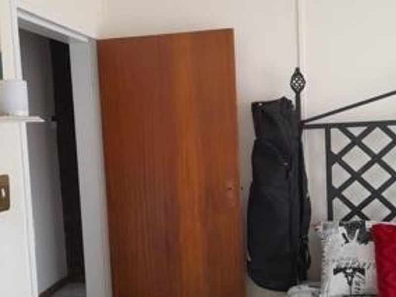 A view of a bedroom interior featuring a wooden door and standard light switch.