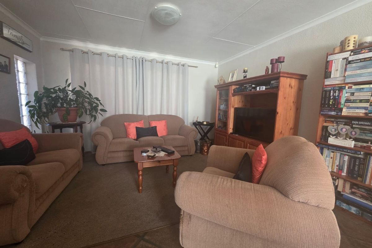 A comfortable living room featuring tiled flooring and neutral wall finishes, providing a functional space for relaxation and family gatherings.