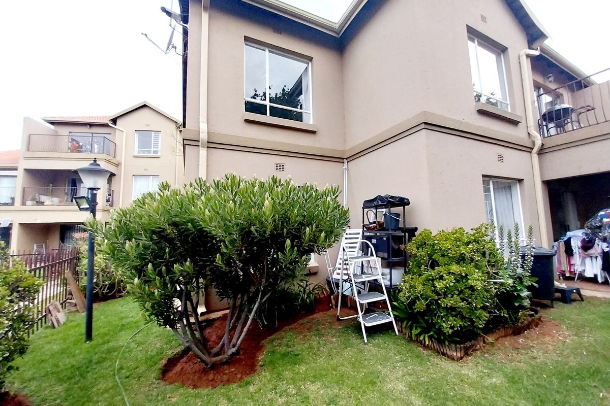 Rear view of the townhouse showing the building facade, garden area, and established landscaping.