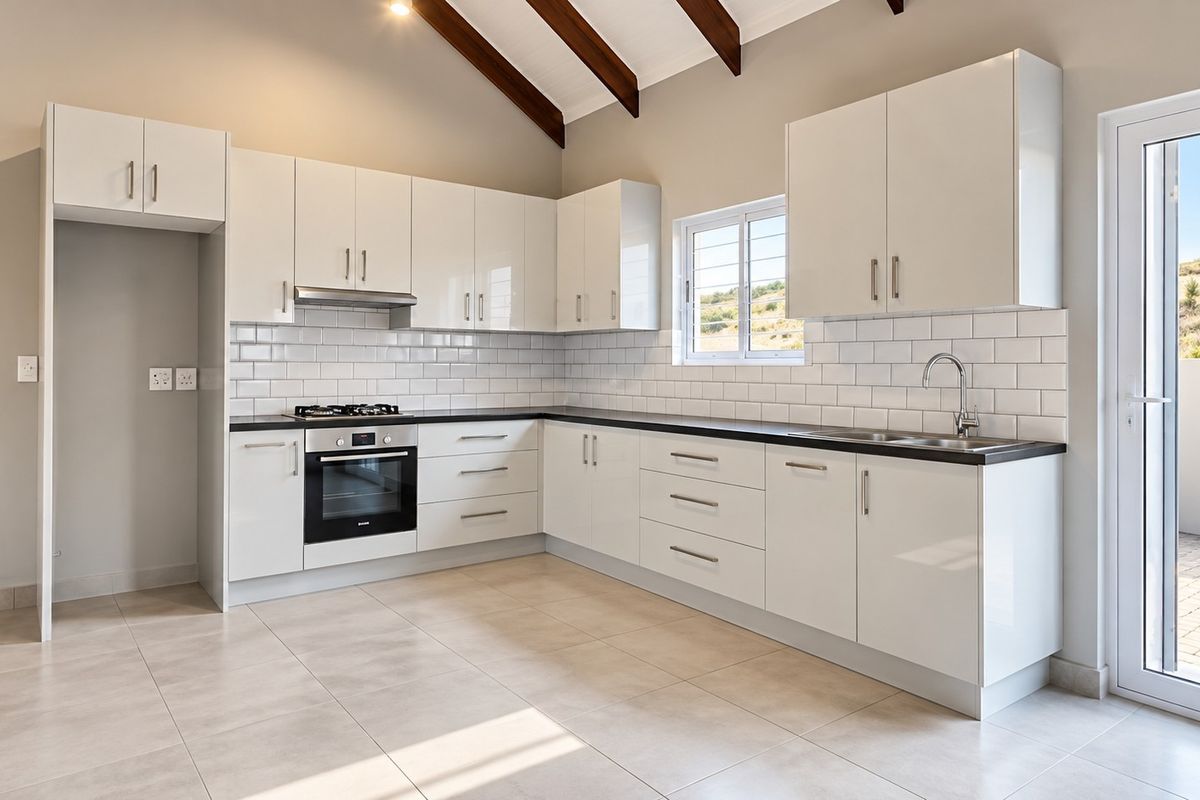 Modern kitchen featuring white cabinetry, subway tile backsplash, built-in oven and hob, and exposed timber ceiling beams with direct access to an outdoor patio.