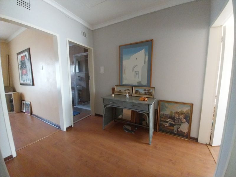 A functional hallway area featuring laminate flooring and neutral wall tones, providing access to adjacent rooms within the townhouse.