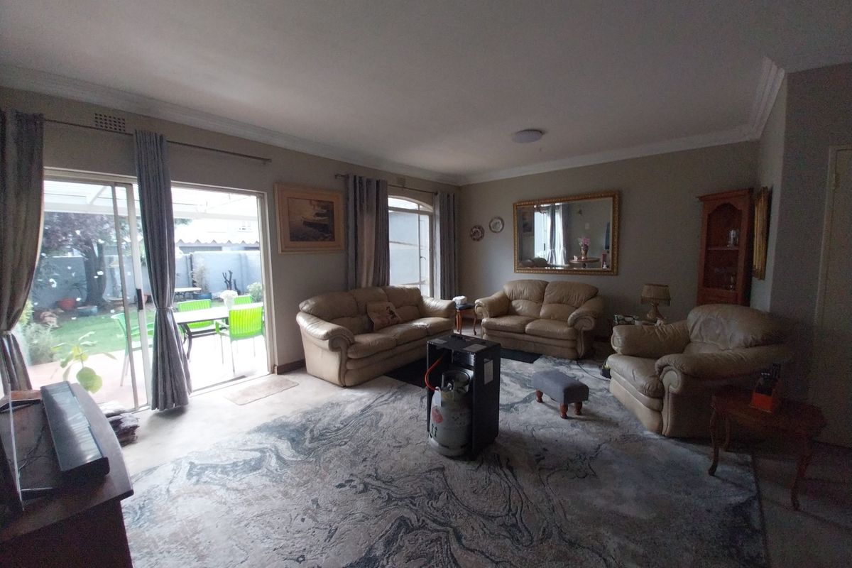 Spacious living room featuring large sliding glass doors that provide natural light and direct access to the outdoor patio area.