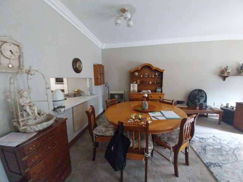 Dining room featuring a serving hatch to the kitchen, coved ceilings, and neutral wall finishes.